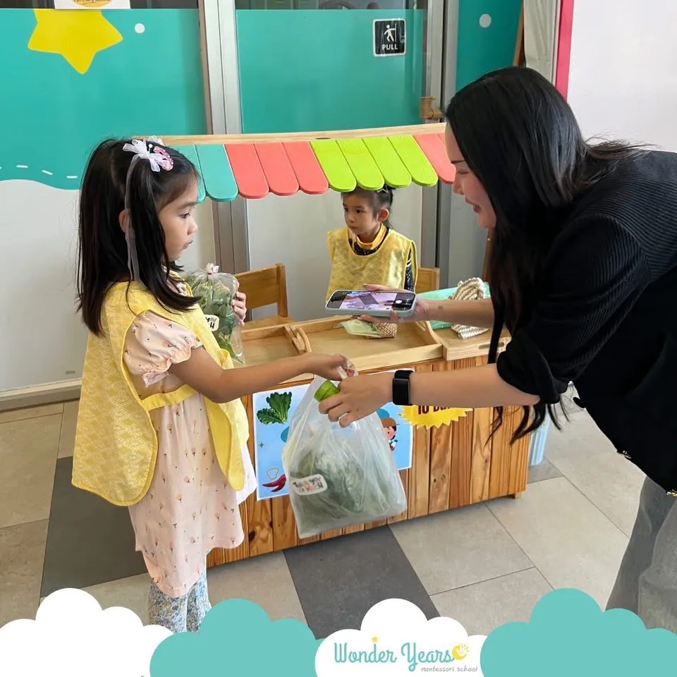 A girl hands a bag of vegetables to an adult customer